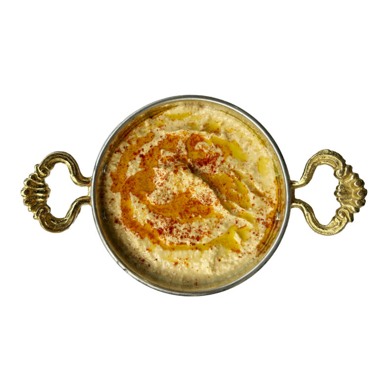Hummus served in a copper dish with olive oil